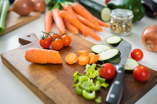 Close up of cutting board with fresh organic sliced vegetables
