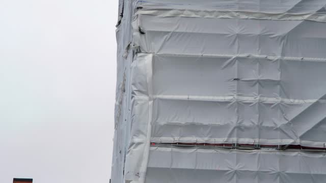 Flame retardant scaffold sheeting wrapped apartments building during insulation in england uk