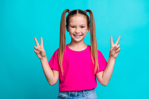 Photo of cheerful lovely girl hands fingers demonstrate v-sign hello greetings symbol isolated on aquamarine color background.