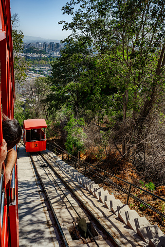 red cable car coming up hill in Santiago de Chile