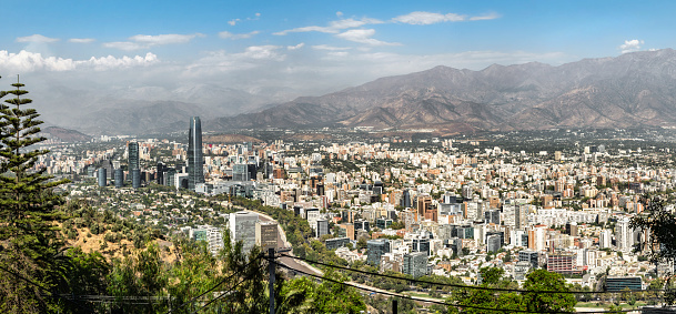 wide elevated panoramic view on modern Santiago skyline with mountain range in the background, stitched image