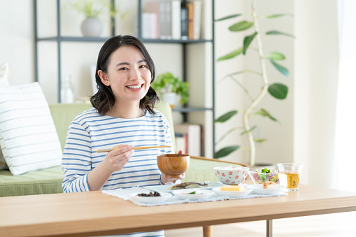 Young woman eating breakfast in the living room