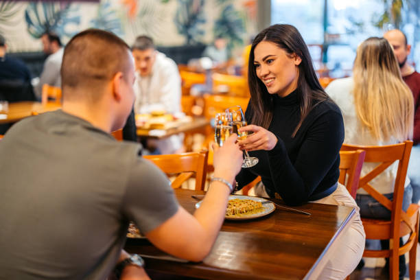 young couple cheering with champagne while eating belgian waffles in a pub - waffle eating meal food and drink zdjęcia i obrazy z banku zdjęć