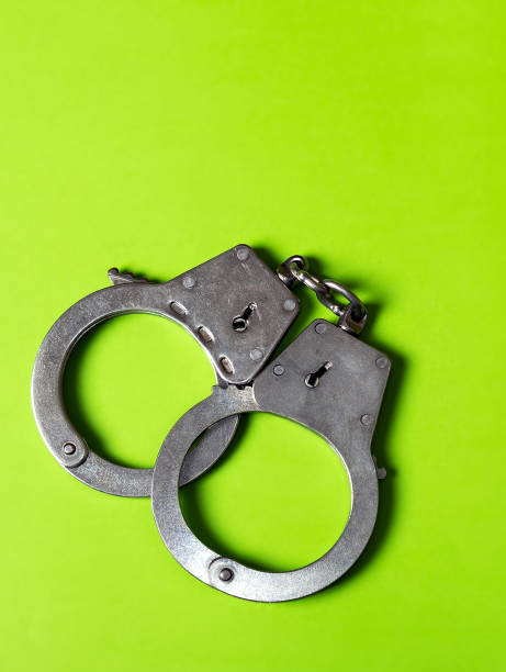 istock Handcuffs on the Green Background 2093944135
