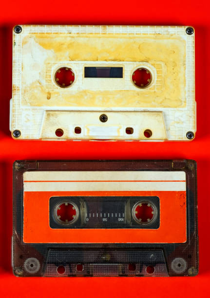 Pair of Old Audio Cassettes on Red Paper Background closeup