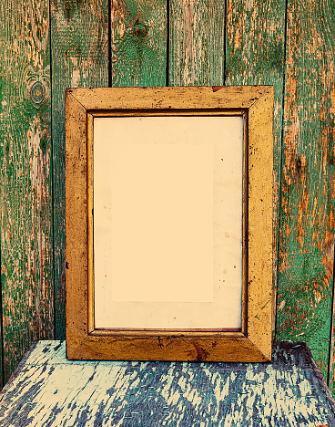 Toned Photo of Old Wooden Frame with Empty Paper on the Weathered Planks Background