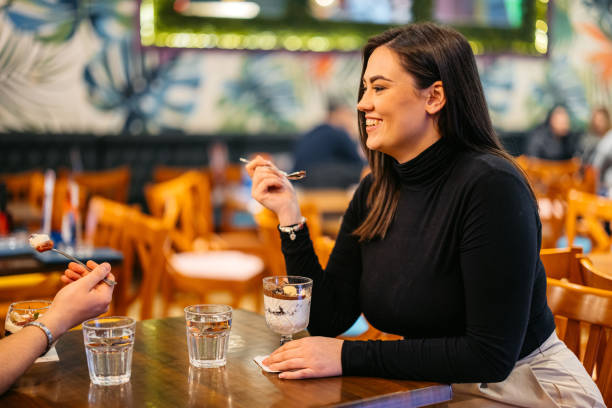 istock Young Woman Eating A Chocolate Dessert In A Pub 2093950388