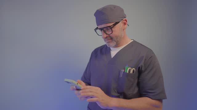 Portrait of a doctor using a smartphone on blue background.