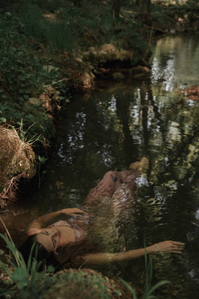 woman floating on the river. - nature zen like stream water stock-fotos und bilder