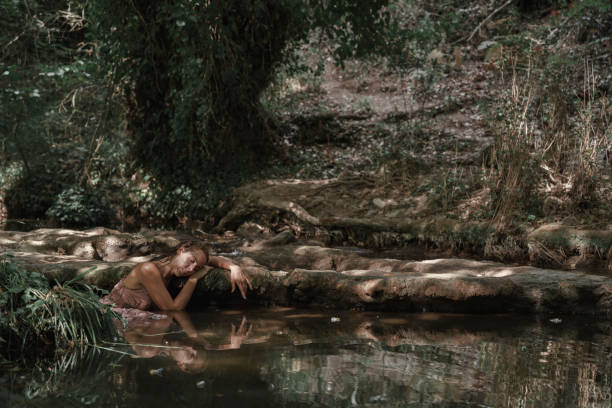 istock Young woman resting on a rock in the water. 2093959845