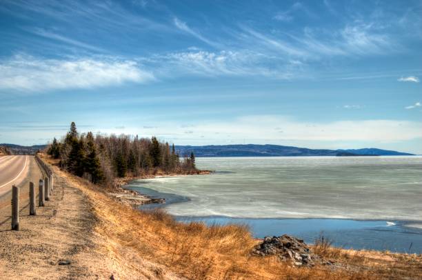 Road passing by a frozen river on a clear day. Alberta, Canada