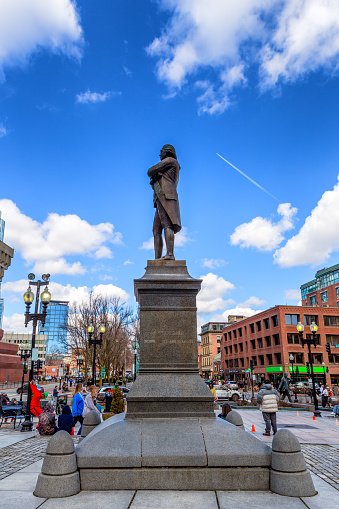 Boston, Massachusetts, USA - March 16, 2024: Side view of the Samuel Adams statue on the Faneuil Hall Plaza. The bronze statue on a granite pedestal was created in 1880 by American sculptor Anne Whitney (1821-1915). Samuel Adams (17221803) was an American Patriot who helped organize the American Revolution, signed the Declaration of Independence, and became Governor of Massachusetts.