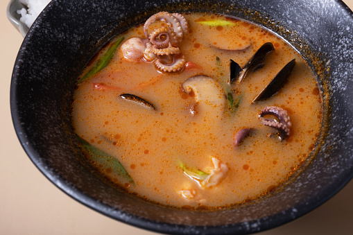 Close up Tom yum soup and rice on a gray background angle view.