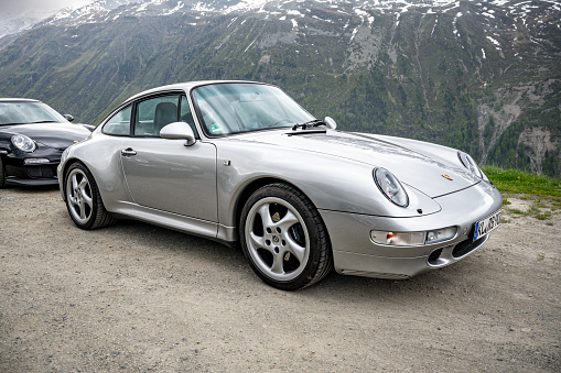 Porsche 911 Carrera S generation 993 parked on the side of the road on the Timmelsjoch Mountain pass in the Austrian Alps.