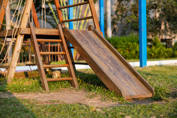 un parque infantil en un parque tropical con tobogán de madera para niños y escaleras de madera en el césped. luz del atardecer. - tropical rainforest rainforest tropical climate formal garden fotografías e imágenes de stock