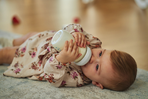 Beautiful baby girl drinking milk.