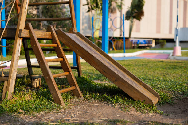 un parque infantil en un parque tropical con tobogán de madera para niños y escaleras de madera en el césped. luz del atardecer. - tropical rainforest rainforest tropical climate formal garden fotografías e imágenes de stock