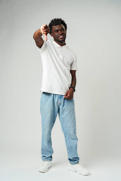 istock Young African Man Giving Thumbs Down Gesture Against a Neutral Background. 2094005645