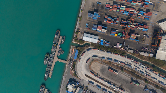 Global logistics business Aerial top view over an international cargo ship at the industrial import and export port preparing to load containers with a large container ship.
