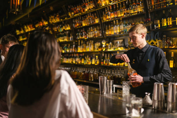 istock Male bartender holds liquor making cocktail for visitors 2094059185