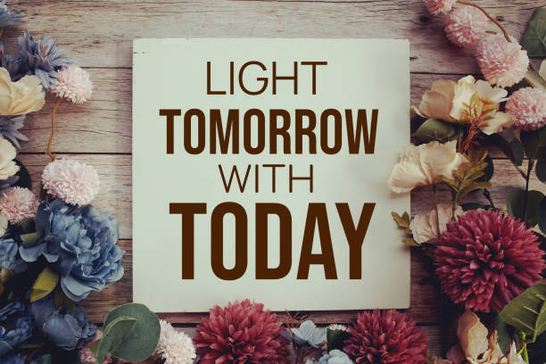 istock Light tomorrow with today text message motivational and inspiration quote with flower decoration on wooden background 2094063960