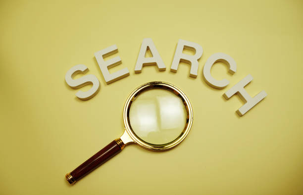 istock Search alphabet letters and magnifying top view on yellow background 2094072962