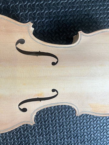Raw violin made from wood put on background,show detail of acoustic instrument