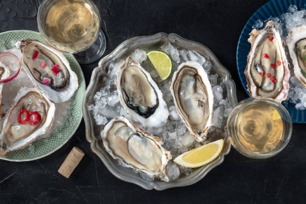 istock Oysters on ice, with various toppings and white wine, overhead flat lay shot 2094103455