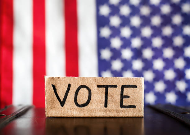 istock USA flag with vote text, election background 2094109835