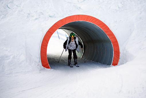 Teenage boy skiing through a fun tunnel at a ski resort in the Alps mountains on a sunny winter day
Sunny winter day.
Shot with Canon R5.