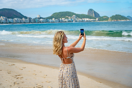 Women taking selfie and enjoying her vacation in beautiful and magical city of Rio de Janeiro and its famous places. Sugarloaf Mountain in Rio de Janeiro, Brazil.