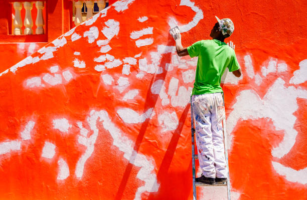 Cape Town, South Africa, February 9, 2018: A worker is patching wall of a landmark house in Bo-Kaap district of Cape Town, South Africa