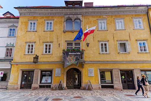 Old town of Slovenian City of Kranj with town hall at Glavni Square and flags on a sunny summer day. Photo taken August 10th, 2023, Kranj, Slovenia.
