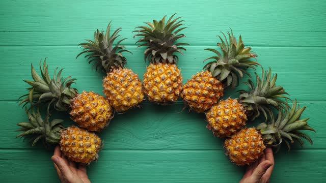 Stop motion clip of fresh whole pineapple fruit being gathered together then chopped and sliced and eaten.