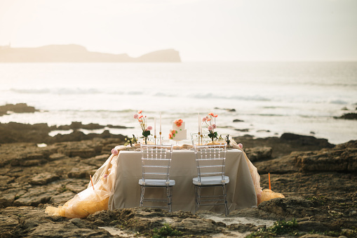 A beautifully decorated dining table placed in a rock by the sea
