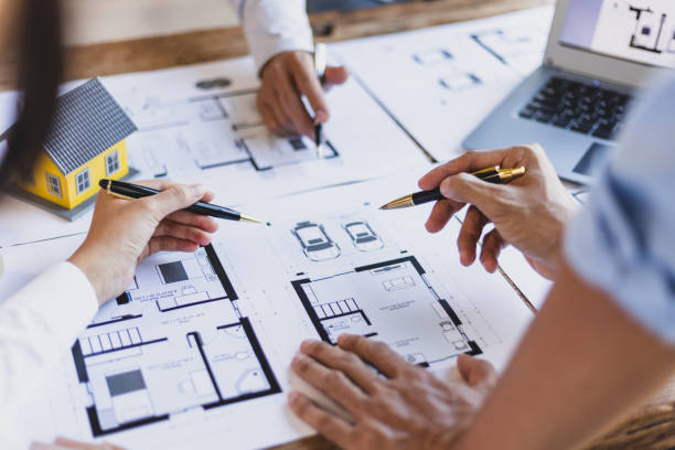 istock Brainstorming group of architects and engineers discuss building blueprint design and construction project planning on wooden table in office. 2094182664