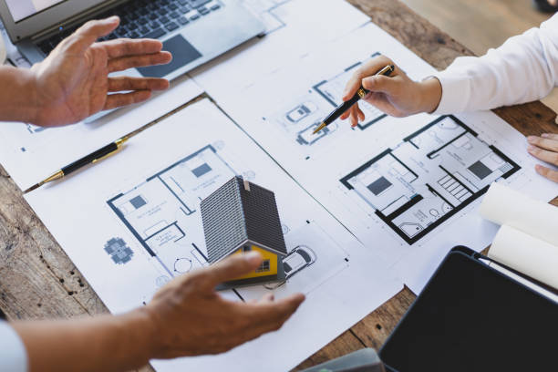 istock Brainstorming group of architects and engineers discuss building blueprint design and construction project planning on wooden table in office. 2094183705