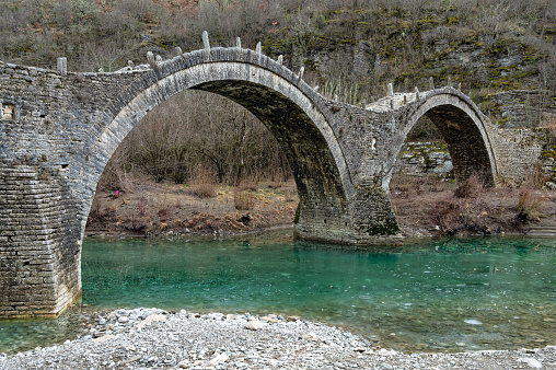 View of the traditional stone Kalogeriko or Plakidas bridge in Zagori of Epirus, Greece in Winter