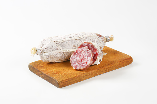 Dry cured French sausage on wooden cutting board