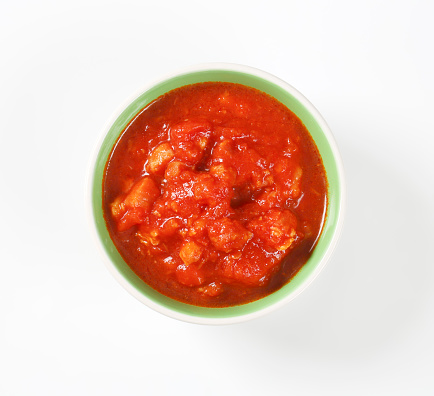 Sauce bowl with ketchup on a white background. A portion of tomato sauce.