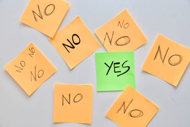 istock Yes written on a green post-it note admist many no 2094206782