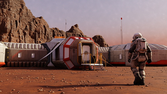 Astronaut strides towards modular space habitat on Mars, against a backdrop of towering rock formations. 3d render