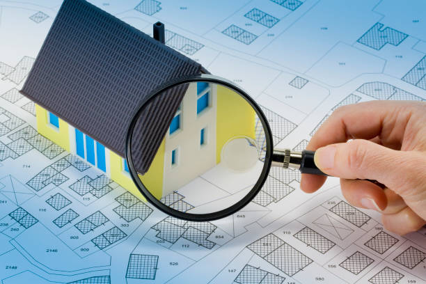 istock Searching new home - Concept with home model, magnifying glass and imaginary cadastral map 2094233568