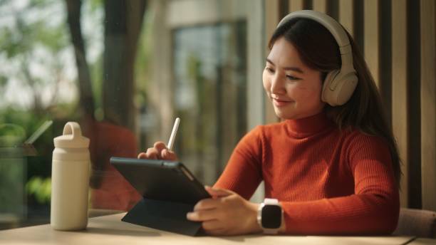 istock Asian woman drawing on her tablet. 2094236467