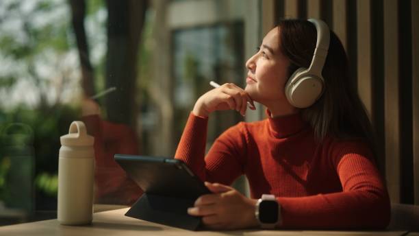 Asian woman drawing on her tablet.