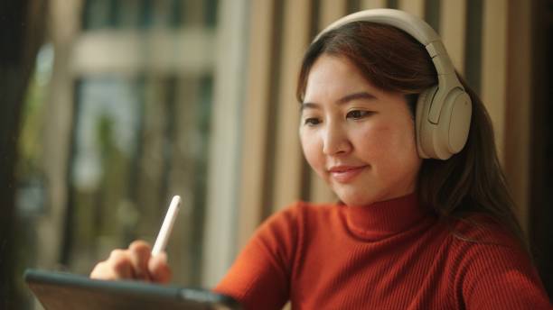 istock Asian woman drawing on her tablet. 2094236799