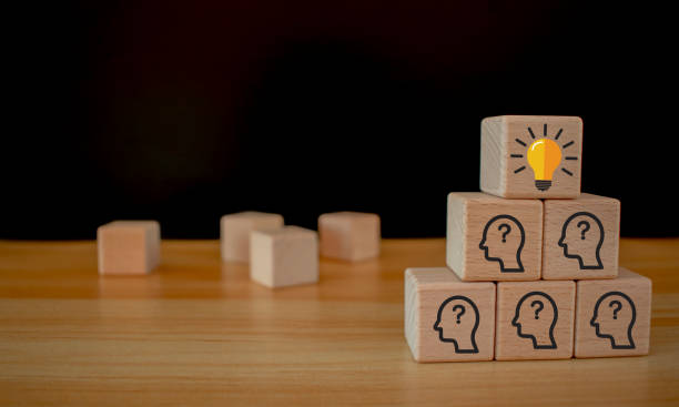 istock Team creative idea or innovative idea concept, Brainstorming process, Wooden blocks with question mark head icon stacked in pyramid stair shape and the top one with light bulb. 2094241810