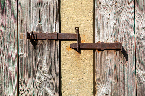 Rusty latches of old wooden doors at a barn