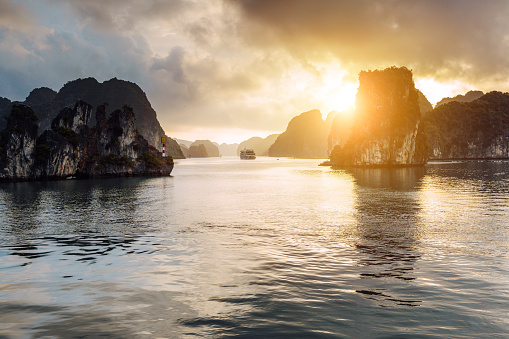 Majestic sunset over Halong Bay, showcasing the tranquil waters and towering limestone islands of this iconic Vietnamese landmark.