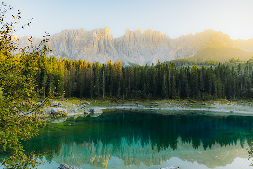 Idyllic view of scenic sunset at Later Mountain range with view of beautiful peaks, pine forest and crystal blue lake